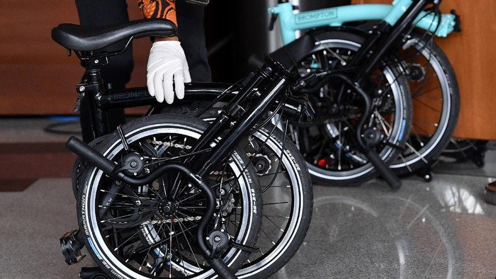 Perantara anggota Komisi II DPR Fraksi PDIP Ihsan Yunus, Agustri Yogasmara membawa barang bukti sepeda Brompton saat rekonstruksi perkara dugaan korupsi pengadaan bantuan sosial Kementerian Sosial untuk penanganan COVID-19 di gedung KPK, Jakarta, Rabu (10/2/2021). ANTARA FOTO/Sigid Kurniawan/rwa.