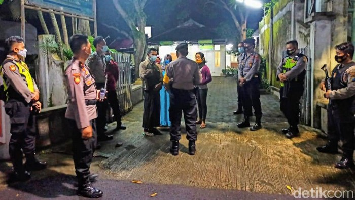 Seorang anak di Bondowoso menolak jenazah ibunya dimakamkan dengan protokol COVID-19. Ia mengancam akan membakar mobil polisi sambil mengacungkan samurai.
