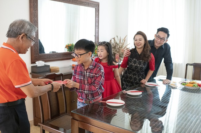 angpao grandfather giving red packet angpao to his grandson during chinese new years eve reunion dinner