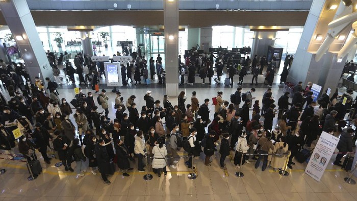 Passengers wearing face masks to help protect against the spread of the coronavirus line up to board planes on the eve of Lunar New Year holiday at the domestic flight terminal of Gimpo airport in Seoul, South Korea, Thursday, Feb. 11, 2021. (AP Photo/Ahn Young-joon)