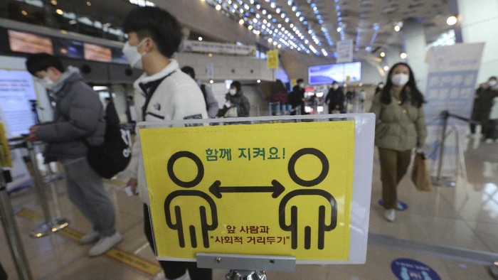 Passengers wearing face masks to help protect against the spread of the coronavirus line up to board planes on the eve of Lunar New Year holiday at the domestic flight terminal of Gimpo airport in Seoul, South Korea, Thursday, Feb. 11, 2021. (AP Photo/Ahn Young-joon)