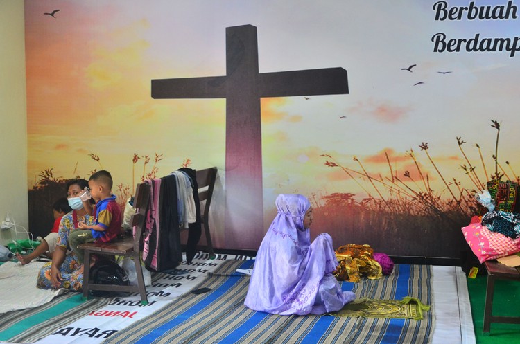 Pengungsi korban banjir berdoa usai melakukan shalat di ruang aula Gereja Kristen Muria Indonesia (GKMI) Tanjung Karang, Kudus, Jawa Tengah, Kamis (11/2/2021). Menurut pengurus gereja setempat, sebagai bentuk toleransi antarumat beragama serta wujud saling membantu kepada sesama, sebanyak 41 warga korban banjir dari berbagai agama dievakuasi ke gereja tersebut sejak 31/1/2021. ANTARA FOTO/Yusuf Nugroho/aww.