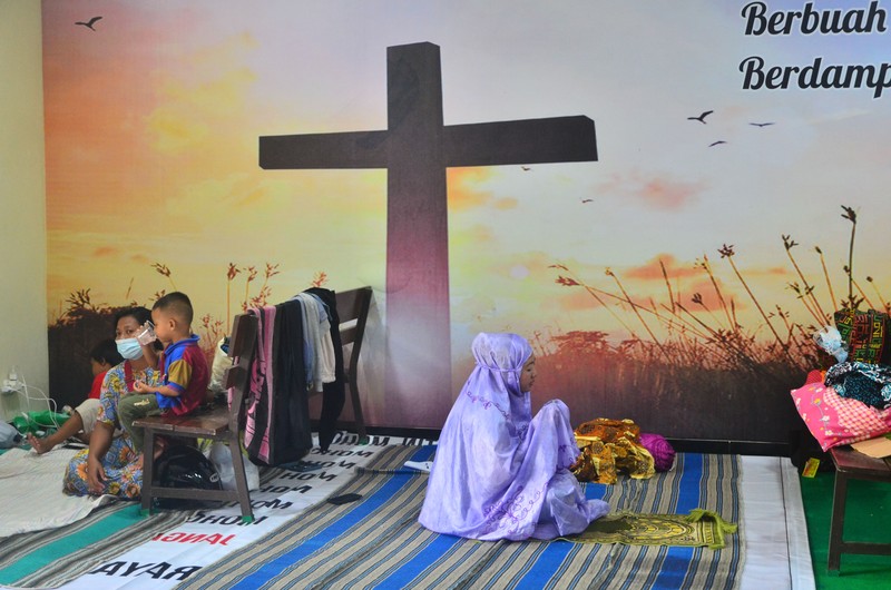 Pengungsi korban banjir berdoa usai melakukan shalat di ruang aula Gereja Kristen Muria Indonesia (GKMI) Tanjung Karang, Kudus, Jawa Tengah, Kamis (11/2/2021). Menurut pengurus gereja setempat, sebagai bentuk toleransi antarumat beragama serta wujud saling membantu kepada sesama, sebanyak 41 warga korban banjir dari berbagai agama dievakuasi ke gereja tersebut sejak 31/1/2021. ANTARA FOTO/Yusuf Nugroho/aww.