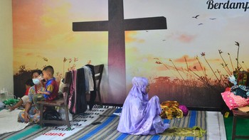 Pengungsi korban banjir berdoa usai melakukan shalat di ruang aula Gereja Kristen Muria Indonesia (GKMI) Tanjung Karang, Kudus, Jawa Tengah, Kamis (11/2/2021). Menurut pengurus gereja setempat, sebagai bentuk toleransi antarumat beragama serta wujud saling membantu kepada sesama, sebanyak 41 warga korban banjir dari berbagai agama dievakuasi ke gereja tersebut sejak 31/1/2021. Foto: ANTARA FOTO/YUSUF NUGROHO