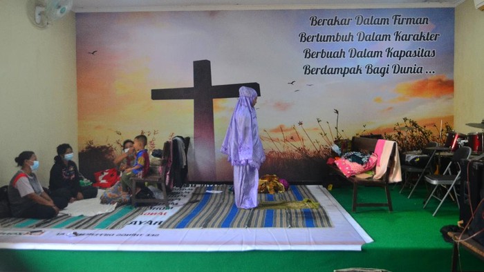 GEREJA UNTUK PENGUNGSIAN KORBAN BANJIR Pengungsi korban banjir berdoa usai melakukan shalat di ruang aula Gereja Kristen Muria Indonesia (GKMI) Tanjung Karang, Kudus, Jawa Tengah, Kamis (11/2/2021). Menurut pengurus gereja setempat, sebagai bentuk toleransi antarumat beragama serta wujud saling membantu kepada sesama, sebanyak 41 warga korban banjir dari berbagai agama dievakuasi ke gereja tersebut sejak 31/1/2021. ANTARA FOTO/Yusuf Nugroho/aww.