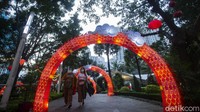 Sejumlah pengunjung melintas di sekitar ornamen Imlek.
