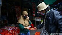 Seorang warga terlihat membeli pernak-pernik Imlek seperti amplop.