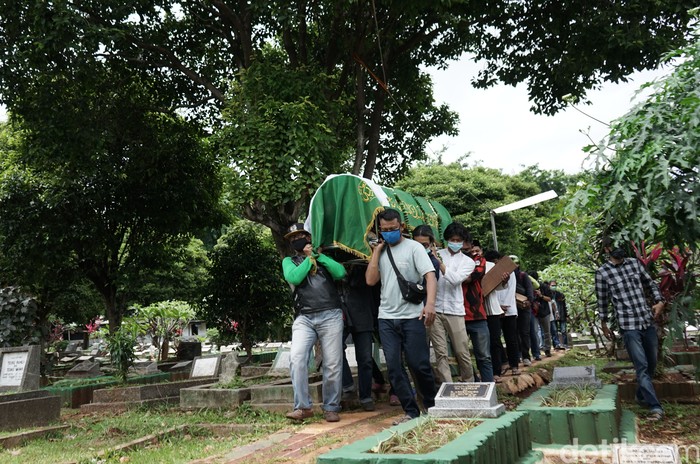 Sejumlah keluarga dan kerabat saat menghadiri pemakaman personil OM PMR, Yuri Anurawan di TPU Gandaria Tengah, Jakarta, Kamis, (11/2/2021).