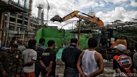 Alat berat itu merobohkan bangunan-bangunan yang telah ditinggal pemiliknya.