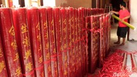 Sejumlah petugas tengah bergotong royong menata lilin berwarna merah yang menjadi representasi doa dan harapan umat untuk menghadapi tahun ini.
