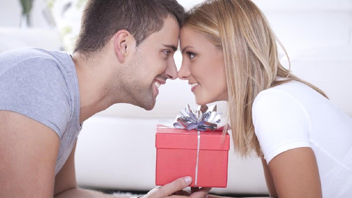 Close up of beautiful young couple and red box gift between them.