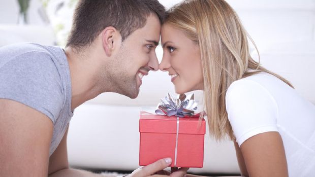 Close up of beautiful young couple and red box gift between them.