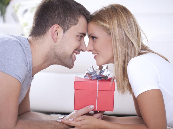 Close up of beautiful young couple and red box gift between them.
