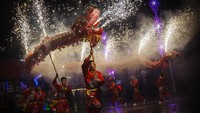 Seniman Tiongkok menampilkan tarian naga di taman hiburan setempat selama perayaan Tahun Baru Imlek 2015, di Beijing, China. Kevin Frayer/Getty Images  