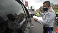 Petugas gabungan Satgas COVID-19 memeriksa kendaraan yang melintas di perbatasan wilayah Jawa Tengah dan Daerah Istimewa Yogyakarta di Jalan Raya Jogja-Magelang, Sleman, DI Yogyakarta, Jumat (12/2/2021).