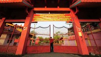 Pengurus menutup pagar Kelenteng Siau San Theng Tua Pek Kong saat Tahun Baru Imlek 2572/2021 di Kampung Manggis, Jambi, Jumat (12/2/2021). Sebagian kelenteng dan vihara di daerah itu ditutup pada 12-14 Februari guna mengantisipasi penyebaran COVID-19. ANTARA FOTO/Wahdi Septiawan.