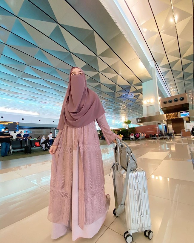 Ketika berada di bandara, Wardah Maulina mengenakan busana serba pastel mocca. Ia memadukan lace long outer dengan gamis mocca dan niqab dengan warna senada. Foto: Dok.Instagram @wardahmaulina_.