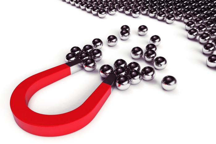 Magnet attracts steel balls from a pile