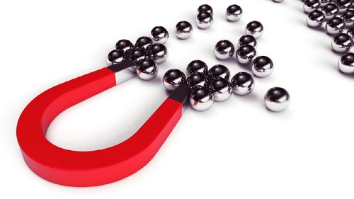 Magnet attracts steel balls from a pile