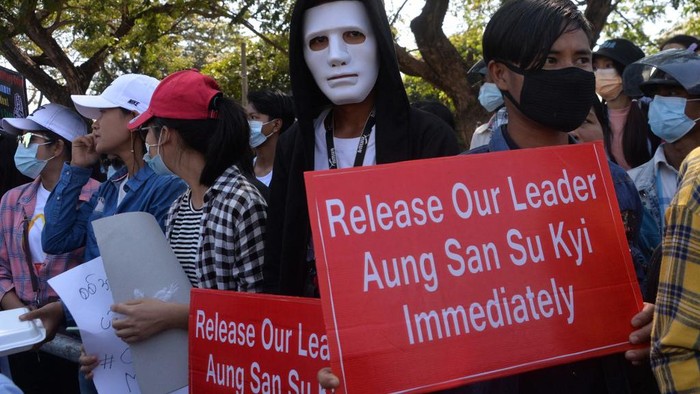 A protester wearing a mask holds up a sign during a demonstration against the military coup in Naypyidaw on February 13, 2021. (Photo by STR / AFP)
