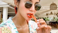 Posenya saat kulineran di pinggir pantai ini mencuri perhatian. Ia berpose sambil menikmati bacon. Berbagai kalimat pujian pun memenuhi kolom komentar di Instagramnya. Foto: Instagram @kiranalarasati