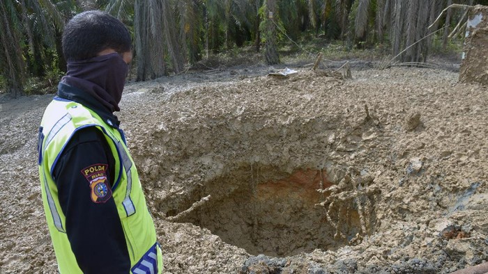 Sejumlah pekerja EMP Bentu mengoperasikan alat berat di tempat semburan gas bercampur lumpur,  di Pondok Pesantren Al-Ihsan, Kota Pekanbaru, Riau, Sabtu (13/2/2021). Tim Dinas ESDM Riau dan perusahaan gas EMP Bentu mulai melakukan proses penutupan lubang berdiameter enam meter dan kedalaman diperkirakan sekitar 119 meter, setelah memastikan semburan gas dan lumpur yang berbahaya sudah berhenti. ANTARA FOTO/FB Anggoro/hp.