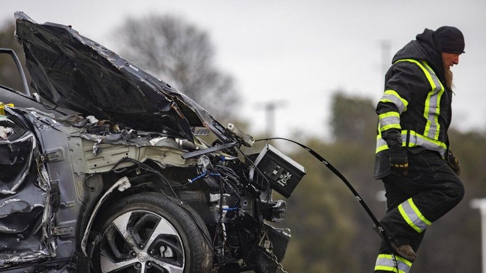 A crumbled car is towed as emergency crews work to clear the pile-up on Interstate 35 in Fort Worth, Texas on Thursday, Feb. 11, 2021. A massive crash involving more than 130 vehicles on the icy Texas interstate left at least six people dead and dozens injured amid a winter storm that dropped freezing rain, sleet and snow on parts of the U.S. (Juan Figueroa/The Dallas Morning News via AP)