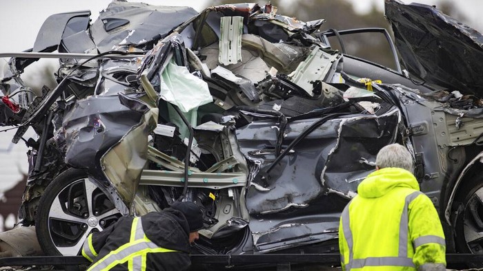 A crumbled car is towed as emergency crews work to clear the pile-up on Interstate 35 in Fort Worth, Texas on Thursday, Feb. 11, 2021. A massive crash involving more than 130 vehicles on the icy Texas interstate left at least six people dead and dozens injured amid a winter storm that dropped freezing rain, sleet and snow on parts of the U.S. (Juan Figueroa/The Dallas Morning News via AP)