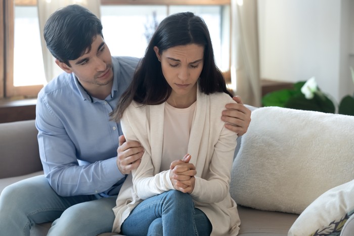 1247241903 Caring young husband touch hug comfort upset beloved woman feeling depressed or anxious about relationships problems, loving man ask forgiveness make peace reconcile with wife after cheating
