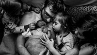 Foto yang diabadikan oleh Ashley Marston dari Kanada, ini menggambarkan seorang ayah yang tengah memeluk buah hati yang baru lahir bersama ketiga orang anak perempuannya. Istimewa/Dok. Ashley Marston via Boredpanda.
