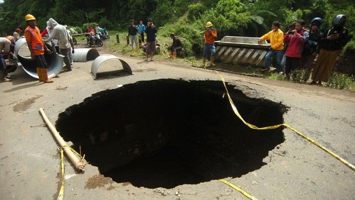 Lubang besar dengan diameter sekitar 8 meter terlihat di jalan penghubung kawasan Brebes dan Tegal. Begini penampakannya.