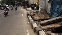 Sejumlah pengendara motor melintas di samping trotoar yang tampak rusak dan tak terawat di kawasan Jalan Raya Cicaheum, Bandung, Jawa Barat, Minggu (14/2/2021).