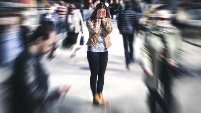 Panic attack in public place. Woman having panic disorder in city. Psychology, solitude, fear or mental health problems concept. Depressed sad person surrounded by people walking in busy street.