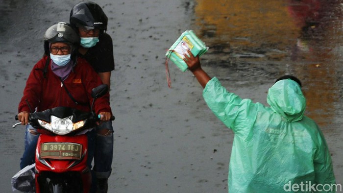 Hujan deras yang mengguyur wilayah Jakarta dan sekitarnya menjadi berkah bagi penjual jas hujan. Dagangannya laris dibeli pengendara sepeda motor.