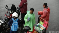 Mereka akan menghampiri pengendara sepeda motor yang berteduh untuk menawarkan jas hujan. 