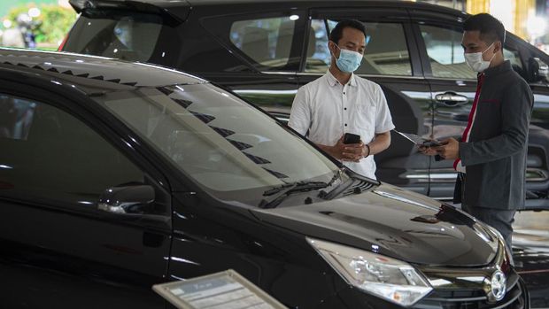 Karyawan menjelaskan salah satu produk mobil kepada calon pembeli di salah satu dealer di Jakarta, Senin (15/2/2021). Pemerintah memberikan keringanan pajak penjualan atas barang mewah (PPnBM) mobil baru ketegori 4x2 atau sedan dengan mesin sampai dengan 1.500 cc mulai Maret 2021 dengan tiga tahap untuk meningkatkan pertumbuhan industri otomotif dengan 'local purchase' kendaraan bermotor di atas 70 persen. ANTARA FOTO/Aditya Pradana Putra/hp.