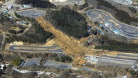 Gempa juga mengakibatkan tanah longsor di Fukushima. Material longsor tampak menutupi jalur sirkuit di kota Nihonmatsu, Fukushima. Sejumlah bangunan di pinggir sirkuit juga tertimbun manterial longsor. AP/Hironori Asakawa  