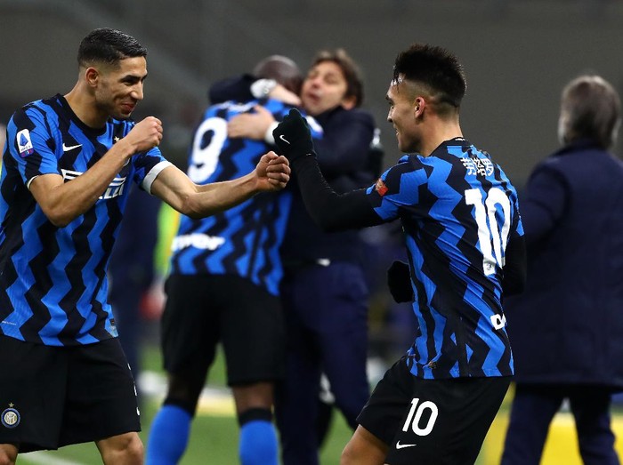 MILAN, ITALY - FEBRUARY 14: Lautaro Martinez of FC Internazionale celebrates with team mate Achraf Hakimi after scoring their side's third goal during the Serie A match between FC Internazionale  and SS Lazio at Stadio Giuseppe Meazza on February 14, 2021 in Milan, Italy. Sporting stadiums around Italy remain under strict restrictions due to the Coronavirus Pandemic as Government social distancing laws prohibit fans inside venues resulting in games being played behind closed doors. (Photo by Marco Luzzani/Getty Images)