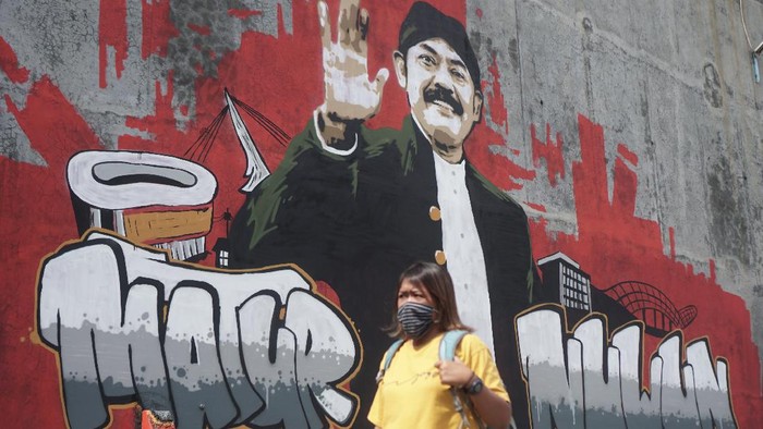 Warga melintas di depan mural bergambar Wali Kota Solo FX. Hadi Rudyatmo di jalan Juanda, Pucang Sawit, Solo, Jawa Tengah, Senin (15/2/2021). Mural tersebut sebagai bentuk apresiasi dan ucapan terima kasih kepada Wali Kota Solo FX. Hadi Rudyatmo yang telah mengabdi selama 15 tahun dan akan segera purna tugas pada 17 Februari 2021 mendatang. ANTARA FOTO/Mohammad Ayudha/hp.
