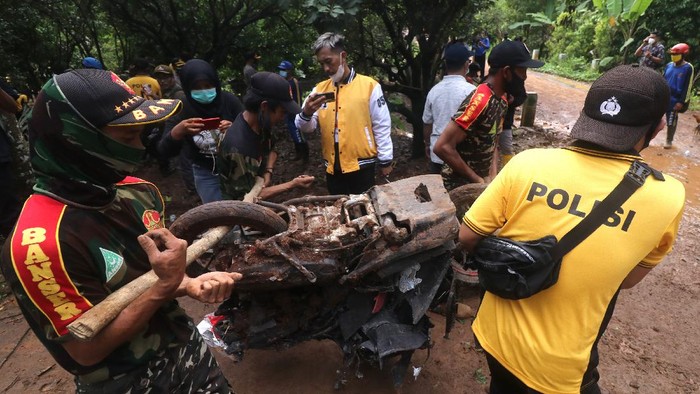 Potret Longsoran Gunung Wilis Nganjuk yang Timbun 16 Orang Petugas mengoperasikan alat berat untuk mencari korban tanah longsor di Desa Ngetos, Nganjuk, Jawa Timur, Senin (15/2/2021). Alat berat dikerahkan di kawasan longsor guna mencari 16 warga yang dinyatakan hilang. ANTARA FOTO/Prasetia Fauzani/rwa.