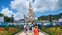 Pengunjung mengambil foto Castle of Magical Dreams di Walt Disney Co.s Disneyland Resort Hong Kong. Disney merancang Disneyland dan taman lanjutannya Disney California sebagai taman bagi keluarga tempat orangtua dan anak-anak. Getty Images/Billy H.C. Kwok  