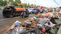 Pengendara melintas di sekitar sampah yang menumpuk di tepi jalur Pantura Losarang, Indramayu, Jawa Barat, Senin (15/2/2021). 