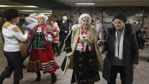 Elderly people dance in a pedestrian subway to mark Valentine's Day ignoring coronavirus quarantine restrictions in Kyiv, Ukraine, Sunday, Feb. 14, 2021. (AP Photo/Efrem Lukatsky)