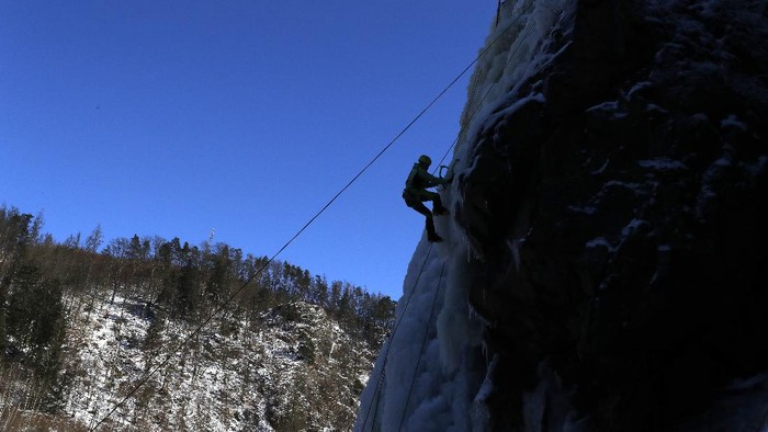 A man climbs down an artificially created ice wall on in the village of Vir, Czech Republic, Sunday, Feb. 14, 2021. (AP Photo/Petr David Josek)