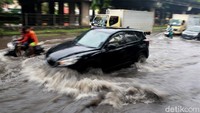 Tak hanya pengendara motor, sejumlah mobil juga tampak menerobos genangan air hujan setinggi 50 cm di kawasan itu.