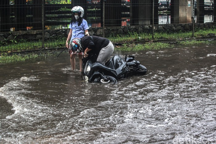 Sejumlah wilayah di Jakarta tergenang air hujan, salah satunya Jalan Lingkar Luar Barat, Cengkareng. Tak sedikit pemotor nekat terobos genangan di wilayah itu.