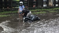 Tak sedikit pengendara motor yang nekat menerobos genangan air di jalan tersebut terjatuh.
