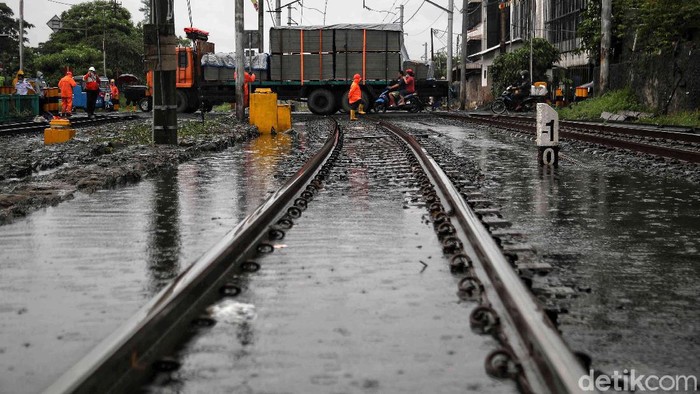 Sebuah kontainer mogok di perlintasan kereta api di Kampung Bandan, Jakarta Utara, Selasa (16/2). Beruntung kontainer berhasil dievakuasi sebelum kereta datang.