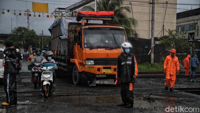 Sebuah kontainer mogok di perlintasan kereta api di Kampung Bandan, Jakarta Utara, Selasa (16/2). Beruntung kontainer berhasil dievakuasi sebelum kereta datang.