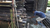 Pekerja menyiapkan bambu yang akan dijadikan kerajinan panel bambu.